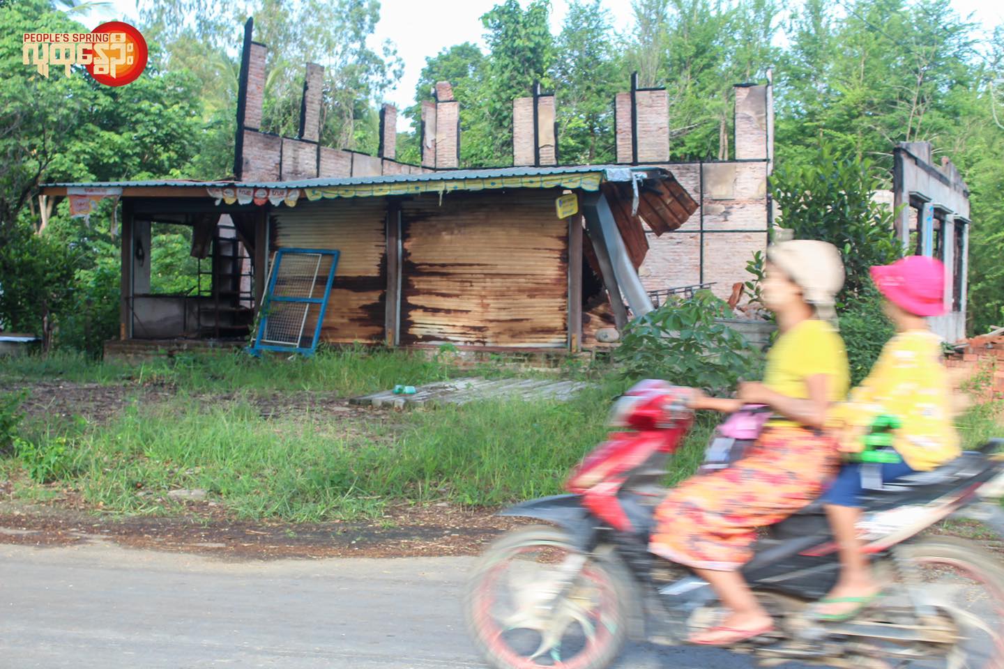 စစ်ကောင်စီတပ် မီးရှို့ဖျက်ဆီးခဲ့သောနေအိမ်အပျက်အစီးအနီးသွားလာနေသောဒေသခံနှစ်ဦး