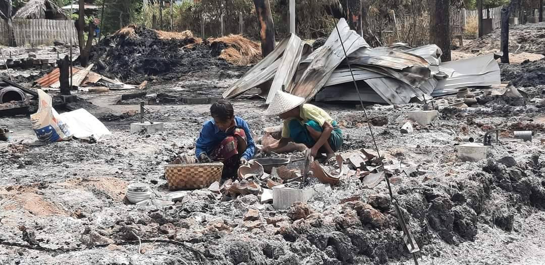 (စစ်ကောင်စီက မူးကမ်းကြီးရွာမီးရှို့ဖျက်ဆီးပြီးနောက် ဒေသခံနှစ်ဦးက ပြာကျသွားသည့် ၎င်းတို့နေအိမ်ဝင်းအတွင်း ပစ္စည်းများ ရှာဖွေနေစဥ်၊ ဓာတ်ပုံ - CJ)