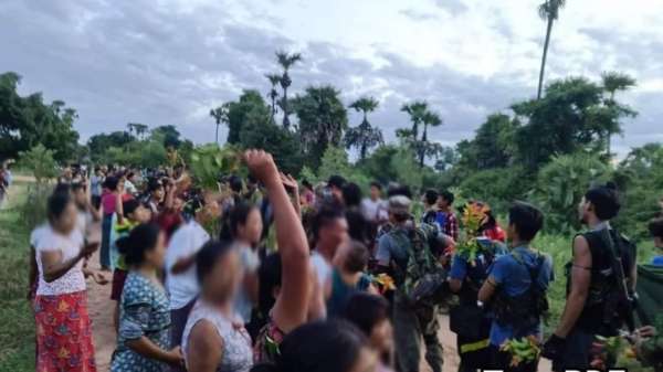 (အောင်ပွဲဖြင့် ပြန်လာသော ပြည်သူ့ကာကွယ်ရေးရဲဘော်များကို ဒေသခံပြည်သူများက သပြေပန်းများဖြင့် ကြိုဆိုနေစဥ်၊ ဓာတ်ပုံ - Taze PDF)