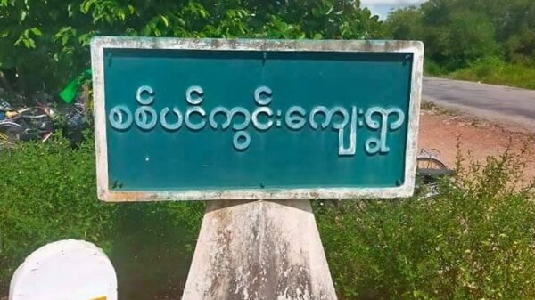 (စစ်ကောင်စီတပ်သား အချင်းချင်းပစ်ခတ်မှု ဖြစ်ခဲ့သည်ဆိုသော စစ်ပင်ကွင်းကျေးရွာအဝင် ဆိုင်းဘုတ်အား တွေ့ရစဥ်၊ ဓာတ်ပုံ - CJ)