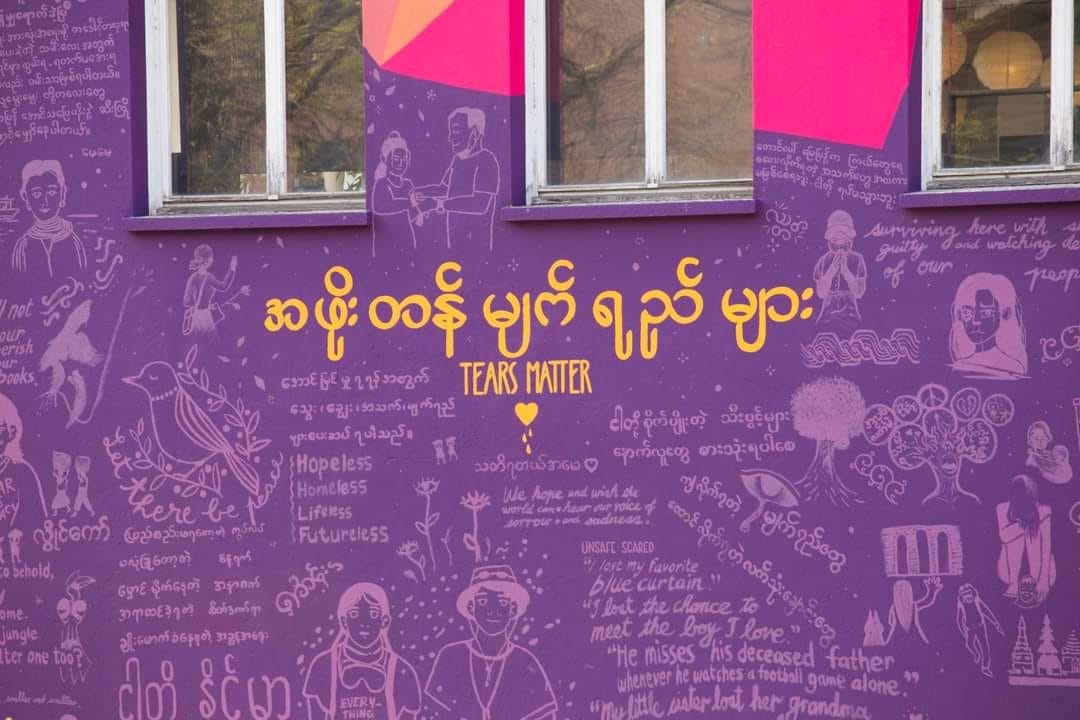 (ပန်းချီဆရာမ ခြူးဝေနှင့် ဆွစ်ဇာလန်နိုင်ငံတွင်သူမရေးဆွဲဖန်တီးထားသော မြန်မာပြည်သူများ၏ခံစားချက်ကိုပဲ့တင်သံထပ်စေသည့်ပန်းချီကားများ။ ဓါတ်ပုံ- ခြူးဝေFB)
