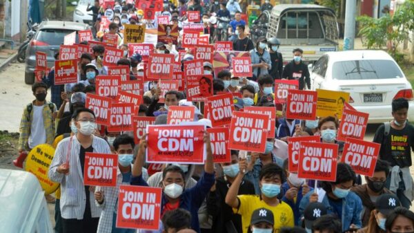 (၂၀၂၁ ခုနှစ် ​ဖေ​ဖော်ဝါရီလလယ်တွင်စစ်အုပ်စုအာဏာသိမ်းမှုကိုဆန့်ကျင်ပြီး အစိုးရဝန်ထမ်းများ CDM လုပ်ကြရန် ဆန္ဒထုတ်​ဖော်​နေ​သောပြည်သူများ။ဓါတ်ပုံ-AFP)