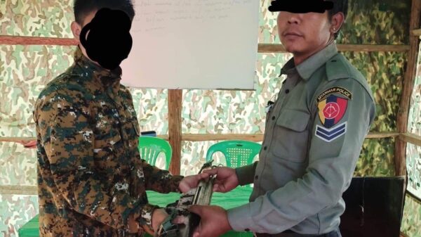 အလင်းဝင်လာသည့် ရံတပ်သားက လက်နက်ပေးအပ်နေစဉ်၊ ဓာတ်ပုံ - ဟားခါး CDF