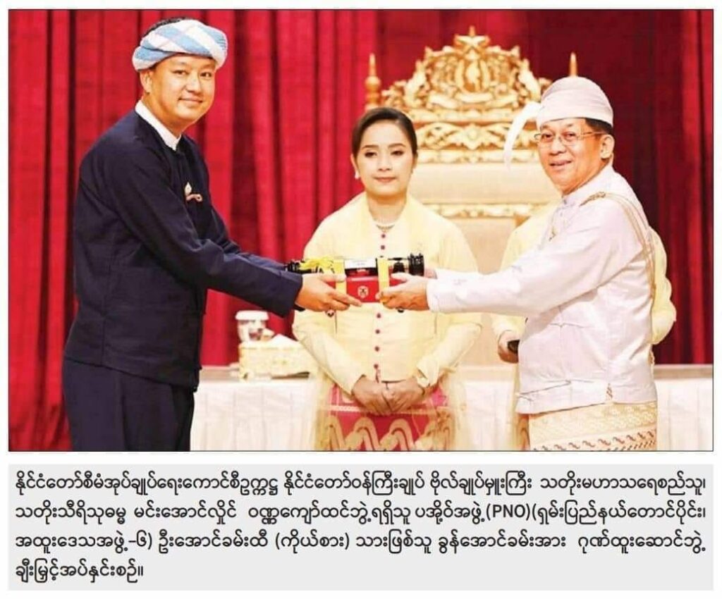 အာဏာသိမ်း​ခေါင်း​ဆောင်က ဝဏ္ဏ​ကျော်ထင်ဘွဲ့ကို ဦး​အောင်ခမ်းထီး(ကိုယ်စား)သားဖြစ်သူ ခွန်​အောင်ခမ်းကို​ပေးအပ်စဥ်။ ဓါတ်ပုံ-စစ်​ကောင်စီ