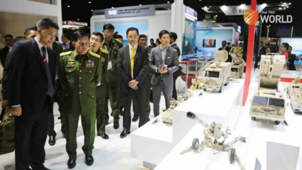 (အ​မေရိကန်က ဒဏ်ခပ်ပိတ်ဆို့ရာတွင်ပါဝင်​သော ထွန်းမင်းလတ်(အဝါ​ရောင်နက်တိုင်ဝတ်ထားသူ) ကို အာဏာသိမ်း​ခေါင်း​ဆောင်နှင့်အတူ ၂၀၁၉ ခုနှစ်က ထိုင်းနိုင်ငံ ၊ဘန်​ကောက်ရှိလက်နက်ပြပွဲတစ်ခုတွင်​တွေ့ခဲရစဥ်။ ဓါတ်ပုံ- Thai PBS)