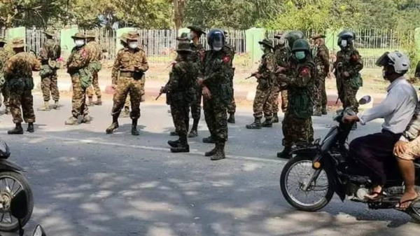 (အာဏာသိမ်းကာလအစပိုင်းတွင် ငြိမ်းချမ်းစွာဆန္ဒပြနေသောပြည်သူများအား အကြမ်းဖက်ဖြိုခွင်းရန်စောင့်နေသည့် စစ်ကောင်စီတပ်သားများအား တွေ့ရစဥ်။ ဓာတ်ပုံ - Cj)