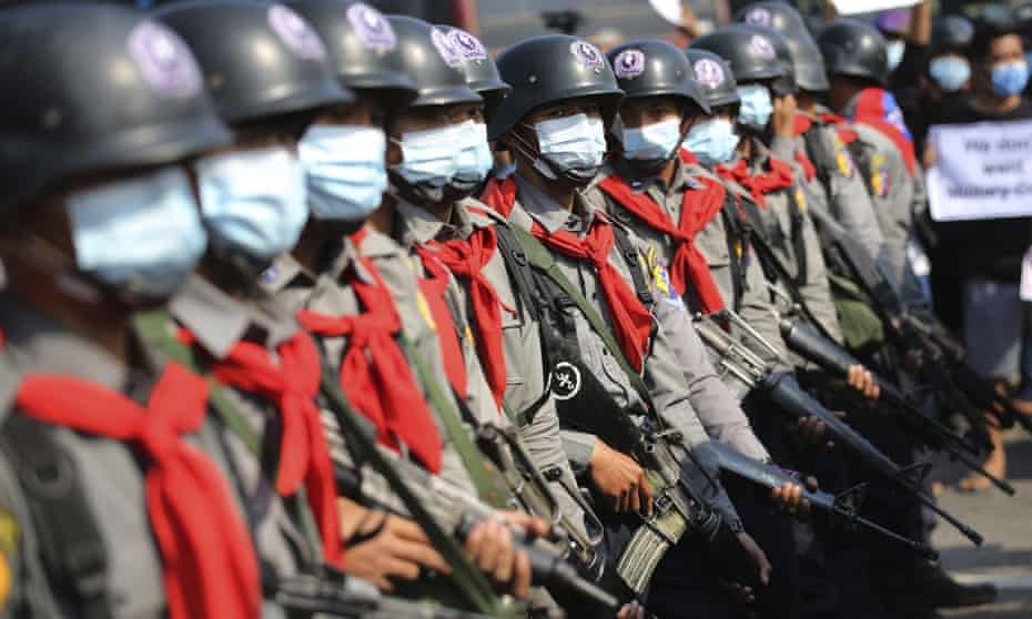 (စစ်အာဏာသိမ်းမှုဆန့်ကျင်​ကြောင်းဆန္ဒပြသူများအား အင်အားသုံးဖြိုခွင်းရန်​စောင့်ကြည့်​နေ​သောရဲတပ်ဖွဲ့ဝင်များကို ၂၀၂၁ ​ဖေ​ဖော်ဝါရီလက​တွေ့ရစဥ်။ဓါတ်ပုံ-The Guardian)