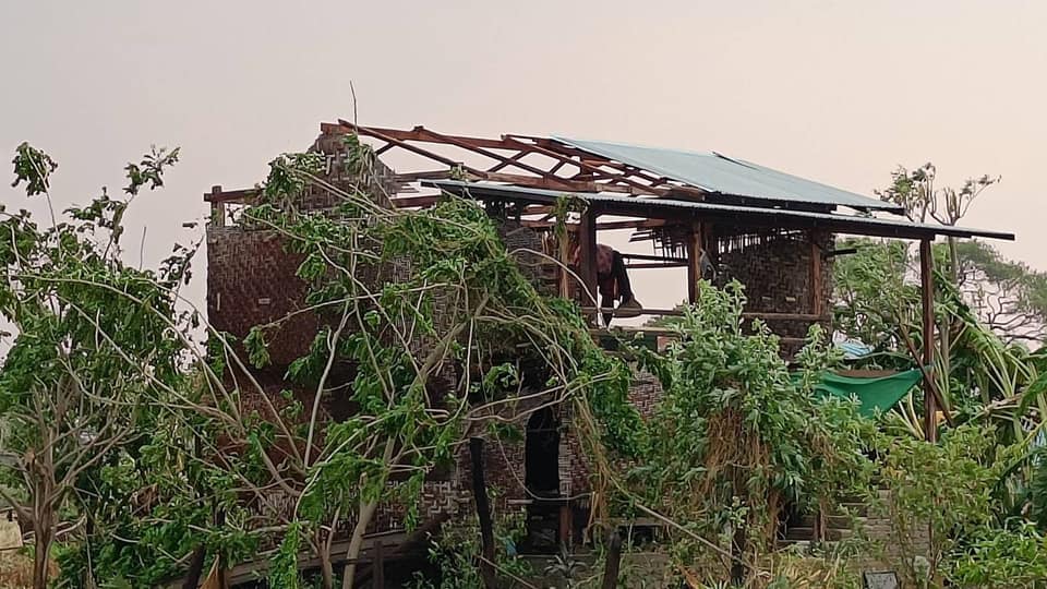 (ကနီမြို့နယ်တွင် လေပြင်းတိုက်ခတ်ပြီး မိုးသီးများကြွေကျပြီးနောက် နေအိမ်အချို့ပျက်စီးနေစဥ်။ဓါတ်ပုံ-CJ)