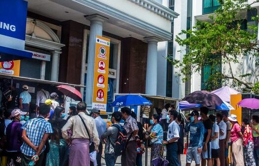 (စစ်တပ်အာဏာသိမ်းလိုက်သဖြင့် CDM မလုပ်ဘဲစစ်​ကောင်စီလက်​အောက်ဖွင့်​သောဘဏ်များကို ပြည်သူများက သပိတ်​မှောသည့်အ​နေဖြသ့်ဘဏ်တွင်​အပ်ထား​သော​ငွေများပြန်ထုတ်ကြရာမှ ဘဏ်များအကျပ်အတည်းဆိုက်ခဲ့ပြီး​ ​ စစ်​ကောင်စီကငွေသားထုတ်​ပေးမှုကိုကန့်သတ်ခဲ့သည်။ထို့သို့ကန့်သတ်သဖြင့်ဘဏ်များအ​ပေါ် ပြည်သူများမယုံကြည်​မှုတိုးလာပြီး ဘဏ်တွင်အပ်ထား​သောမိမိတို့၏ငွေများကို အလုအယက်ပြန်ထုတ်ယူရန် ၂၀၂၁ ​မေလက ကြိုးစား​နေကြစဥ်။ဓါတ်ပုံ-The New York Times)