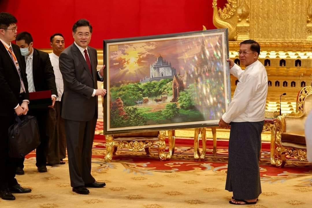 (တရုတ်နိုင်ငံခြား​ရေးဝန်ကြီးကို အာဏာသိမ်းစစ်​ခေါင်း​ဆောင်က လက်​ဆောင်​ပေးအပ်​နေစဥ်။ဓါတ်ပုံ-စစ်​ကောင်စီ)