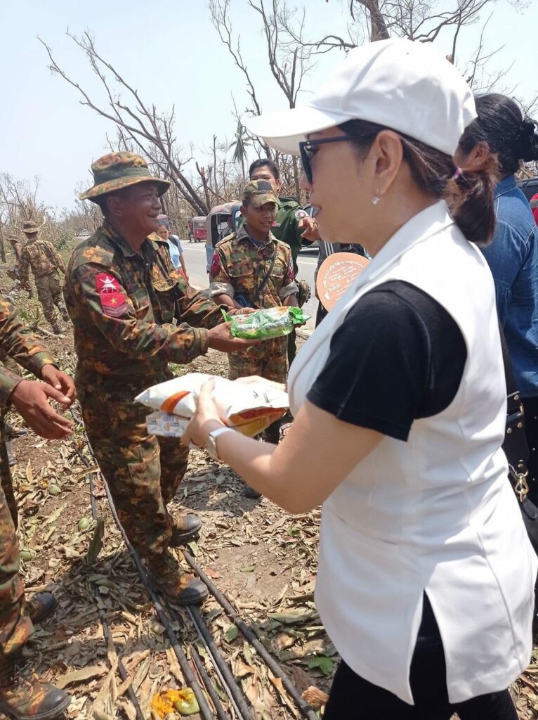 (စစ်​ကောင်စီ၏ စစ်​ရေးပြအခမ်းအနားတက်​ရောက်ရင်းစစ်​ကောင်စီ​ပြောခွင့်ရပုဂ္ဂိုလ်အပါအဝင်စစ်တပ်​ထောက်ခံသူများနှင့် ဓါတ်ပုံရိုက်ကူးခဲ့​စဥ်နှင့်စစ်သားများကို ရိက္ခာ​ဝေ​နေ​သော လီလီ​ကျော်နိုင်။ ဓာတ်ပုံ -လီလီ​ကျော်နိုင်ဖေစ်ဘွခ်)