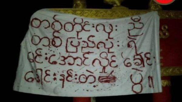 (ပေါင်းတည်မြို့နယ် ရန်ကုန် - ပြည်ကားလမ်းဘေးရှိ မြို့အဝင်ဆိုင်းဘုတ်၌ ချိတ်ဆွဲထားသော စာတန်းအား တွေ့ရစဥ်။ ဓာတ်ပုံ - PPDF)