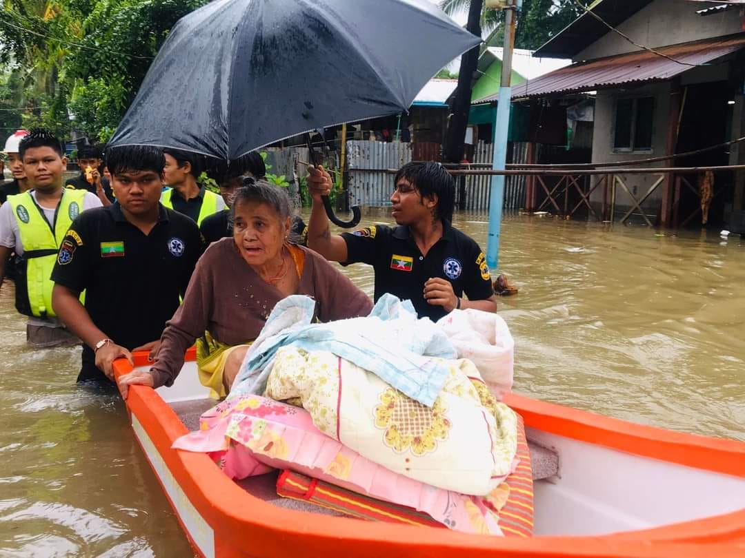 (​ရေကြီး​နေ​သော ရပ်ကွက်များကို လူမှုကူညီ​ရေးအဖွဲ့များက ကူညီ​ရွေ့​ပြောင်း​ပေး ၊ထမင်းထုပ်​ပေး​နေစဥ်နှင့် ​ရေနစ်​နေ​သောက​လေးငယ် ၂ ဦးရှာ​​ဖွေ​နေကြစဥ်။ ဓါတ်ပုံ-ဇင်မိုး)