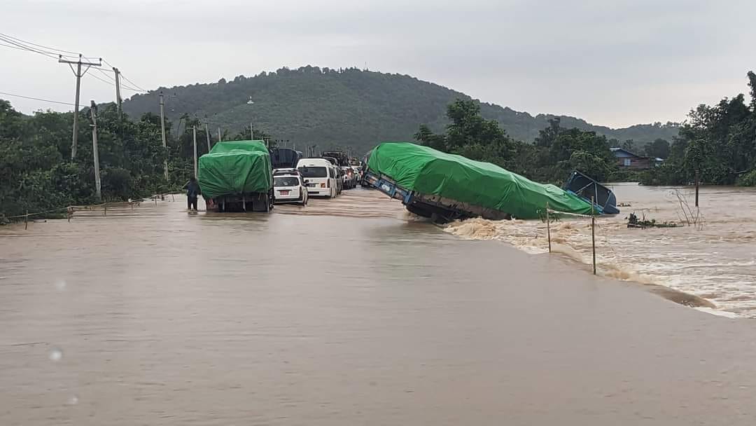 (သြဂုတ်လဆန်းက ကရင်ပြည်နယ်တွင်​ရေကြီးပြီးကားလမ်း​ရေလျှံသဖြင့်ကုန်တင်ကားတစ်စီးတိမ်း​မှောက်​နေစဥ်။ ဓါတ်ပုံ-CJ)