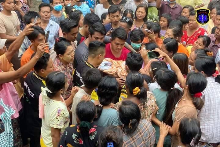 (ကိုယ်ဝန်ဆောင်အမျိုးသမီးနာရေးအား ပြည်သူများ လိုက်ပါပို့ဆောင်နေစဥ်။ ဓာတ်ပုံ - မြန်မာနိုင်ငံလူမှုကယ်ဆယ်ရေးအဖွဲ့)