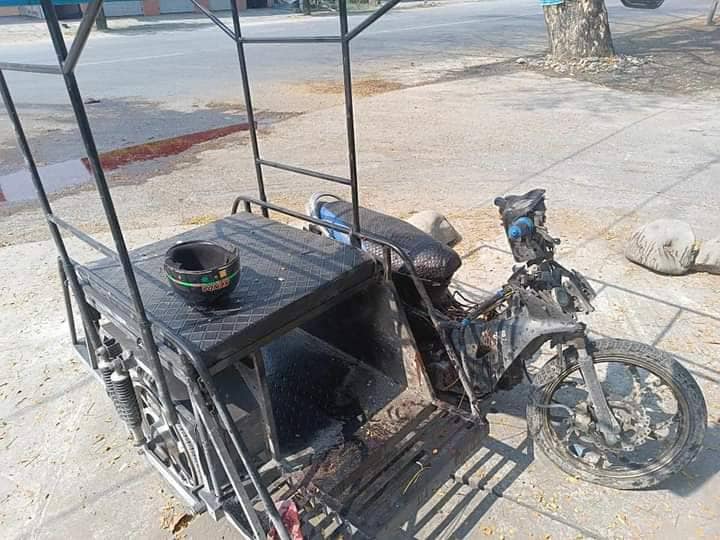 (မိုင်းပေါက်ကွဲသည့်နေရာ နှင့် ပေါက်ကွဲပြီးနောက် ပျက်စီးသွားသည့် သုံးဘီးဆိုင်ကယ် ။ဓါတ်ပုံ-CJ )