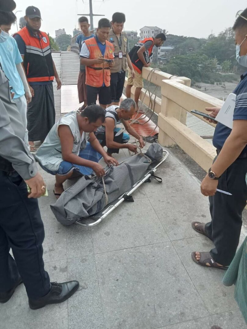တံတား ပေါ်မှ ခုန်ချသတ် သေသွား သောအဖွားနှင့် ရုပ်အ လောင်းကို လူမှုကူညီကယ်ဆယ် ရေးအဖွဲများက တံတား အောက် ခြေမှ ဆယ်ယူစဥ်။ဓါတ်ပုံ-သစ္စာမဏ္ဍိုင် လူမှုကူညီ ရေးအသင်း