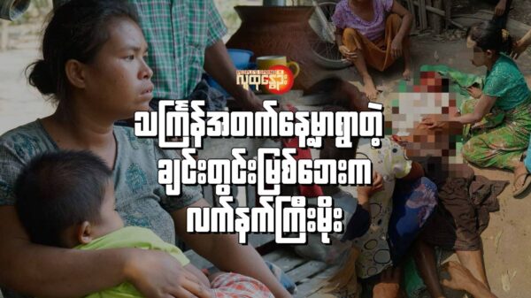 လက်နက်ကြီးထိမှန်သေဆုံးခဲ့တဲ့ ကိုဂွတိုရုပ်အလောင်းဘေးက မိသားစုဝင်များ/လက်နက်ကြီးထိမှန်သေဆုံးခဲ့သူ ကိုဂွတို၏ ကျန်ရစ်ခဲ့သောဇနီးနှင့် သားငယ်အား တွေ့ရစဥ်။