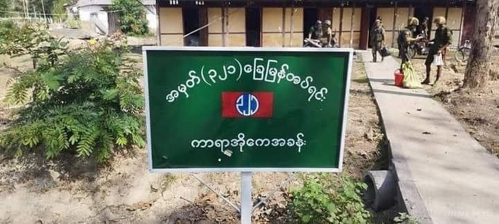 (KIAပူးပေါင်းတပ်သိမ်းပိုက်ရရှိခဲ့သည့် စစ်ကောင်စီ၏ ဝိုင်းမော်အခြေစိုက် ခမရ(၃၂၁) တပ်ရင်း အုတ်ခုံရှေ့၌ မှတ်တမ်းတင်ဓာတ်ပုံရိုက်နေသော ရဲဘော်တစ်ဦး။ ဓာတ်ပုံ - The Kachin Net၊Padang Nesn)
