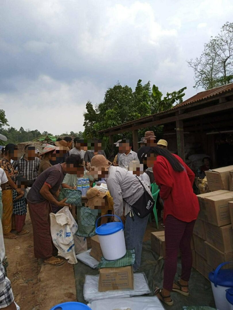 (ဗန်းမောက်မြို့မှ စစ်ဘေးသင့်ပြည်သူများအတွက် ပြည်ပအလှူရှင်များက ပေးပို့သော ကယ်ဆယ်ရေးပစ္စည်းများ ထောက်ပံ့ပေးနေစဉ်။ ဓာတ်ပုံ - CJ)