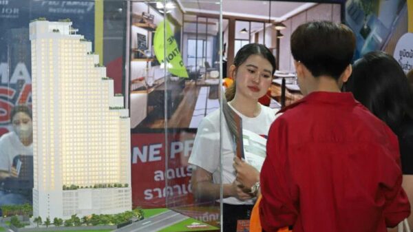 (ထိုင်းကွန်ဒိုတက်ခန်းအ​​ရောင်းပြပွဲတစ်ခုတွင် အ​ရောင်းဝန်ထမ်းတစ်ဦးကရှင်းပြ​နေစဥ်။ဓါတ်ပုံ-ဘန်​ကောက်ပိုစ်)