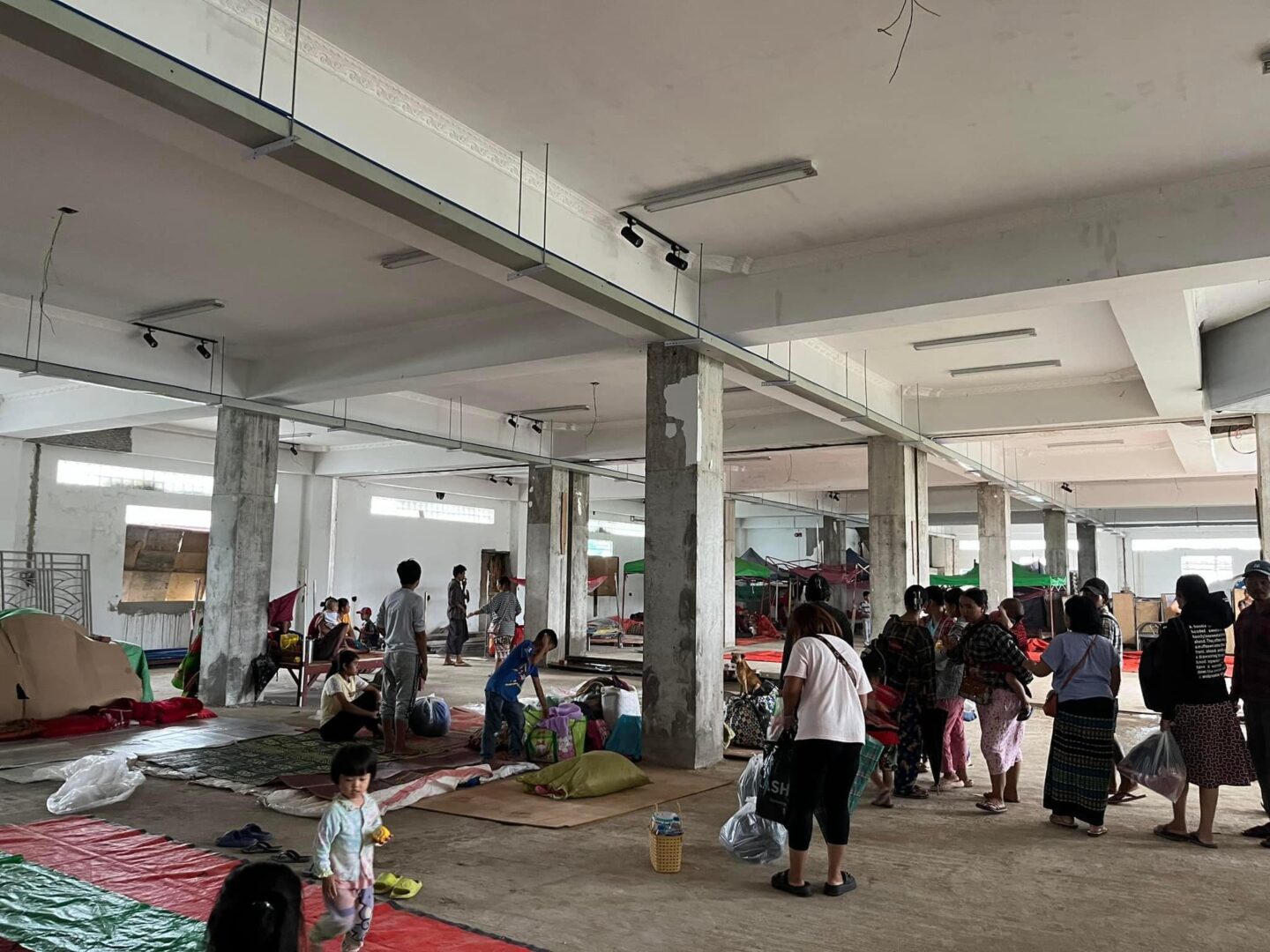 (လားရှိုးမြို့ရှိ ဆောက်လက်စအဆောက်အဦးတစ်ခုတွင် စစ်ဘေးရှောင်နေကြသော ဒေသခံအချို့အား တွေ့ရစဉ်။ ဓာတ်ပုံ - CJ)