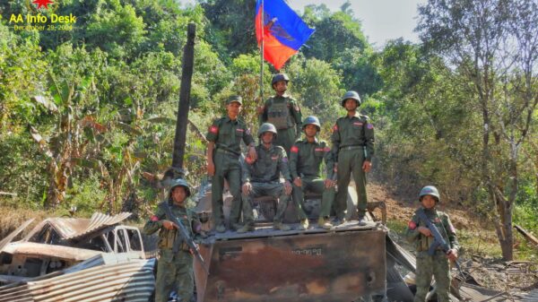 (ဂွမြို့အားသိမ်းပိုက်ပြီးနောက် စစ်ကောင်စီ၏ မီးလောင်နေသော သံချပ်ကာကားပေါ်တွင် အောင်ပွဲခံနေသော AAရဲဘော်များ။ ဓာတ်ပုံ - AA)